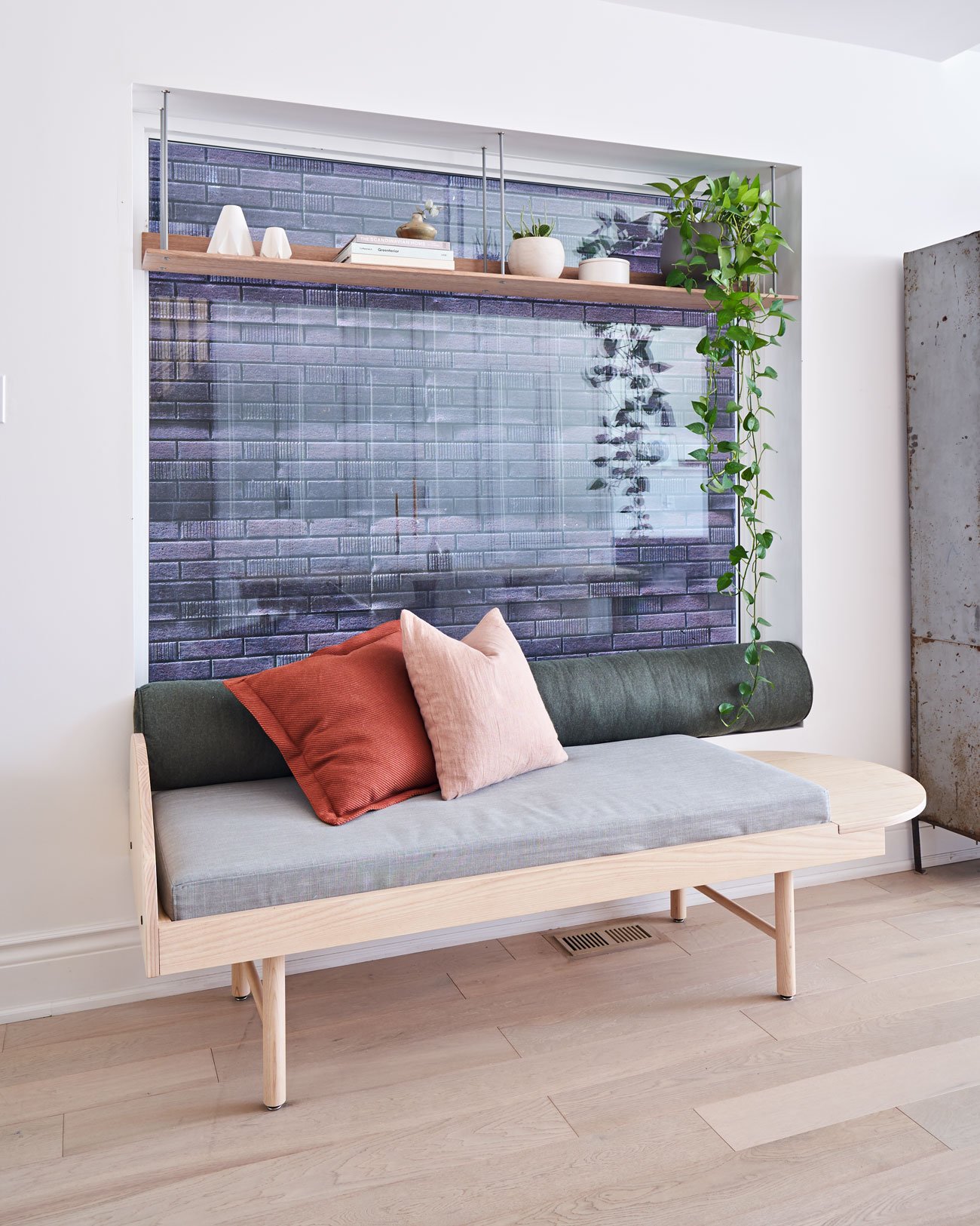 The artist self-designed white oak daybed and floating bookshelf made by Atelier Arking